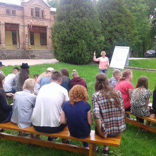 Tēma "Sadarbība" saulainā un zaļā pļavā